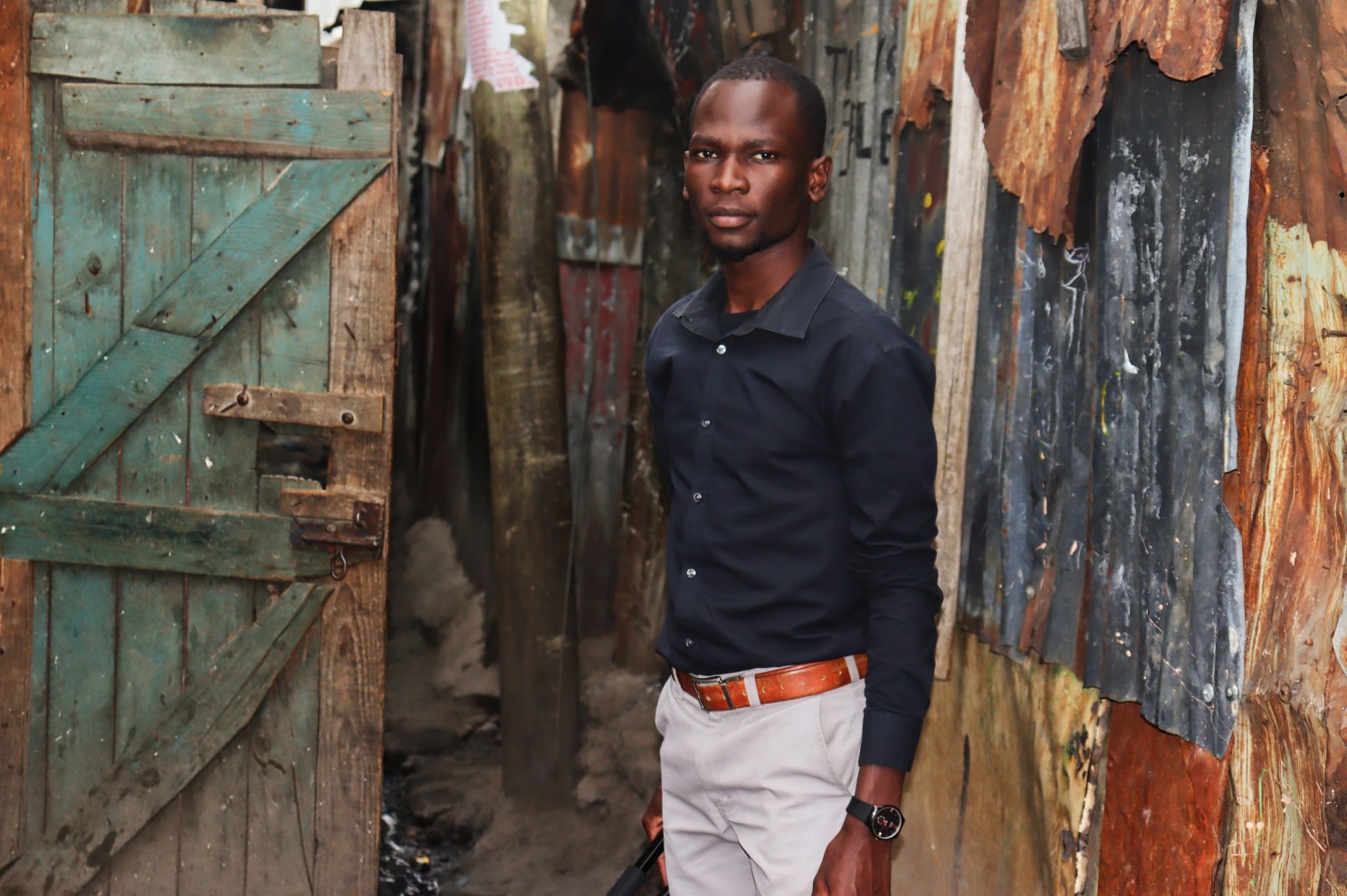 Evans Ijakaa in Kibera while collecting data for ‘The Poverty Industry Story.’ Surrounded by iron-sheet homes and narrow pathways, the image captures the lived realities behind the story.