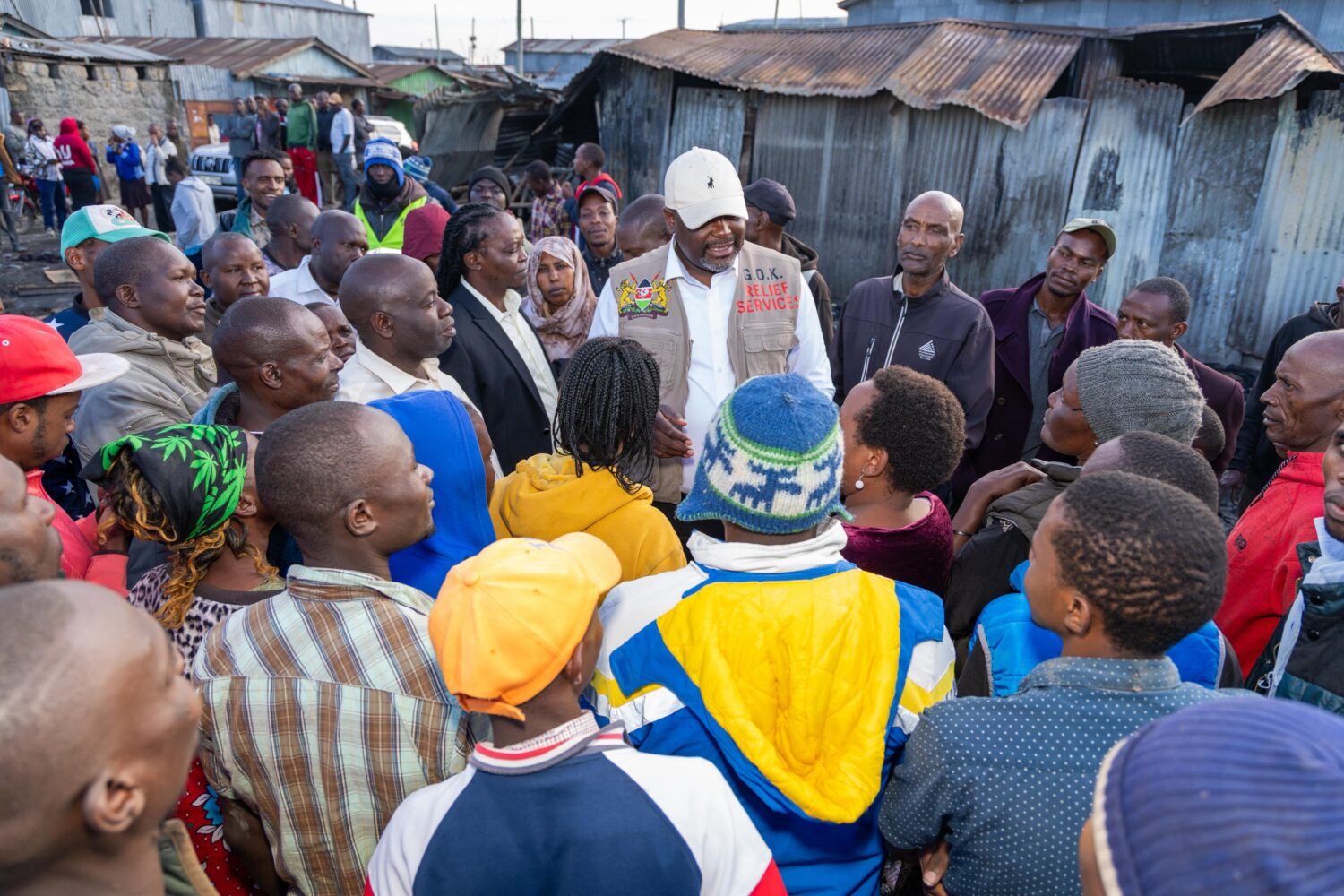 Public Service CS Geoffrey Ruku (center) at Mukuru Kwa Njenga slums with victims of the fire tragedy.