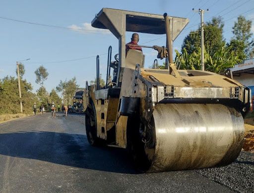 A road roller compacts a freshly laid asphalt surface as construction works progress along the Kathageri-Kigumo-Kanyuambora road corridor in Embu County.